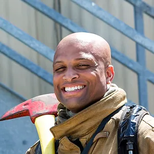 A smiling firefighter in turnout gear